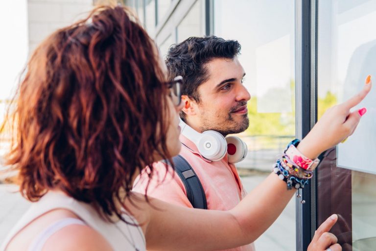 Estudiantes mirando la lista de admitidos en la universidad